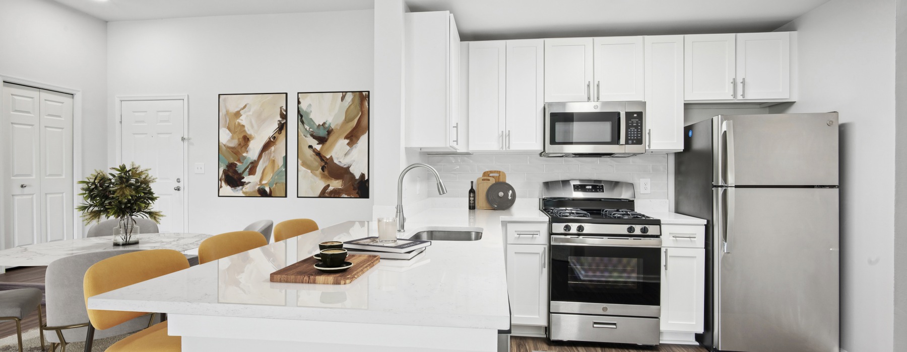 Updated kitchen with white cabinetry and stainless steel appliances.